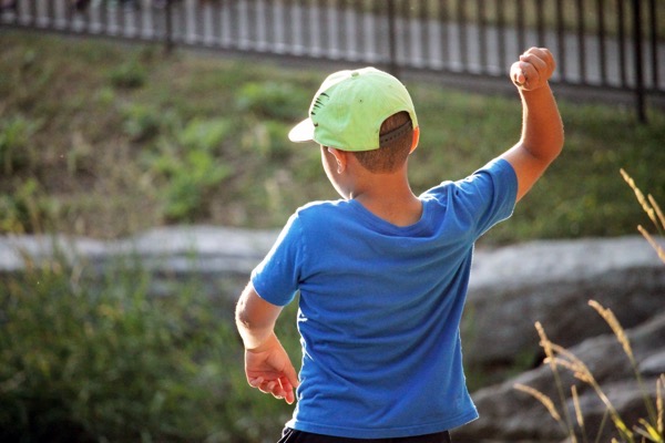 shutterstock_442420324.jpg A young boy getting ready to toss a rock