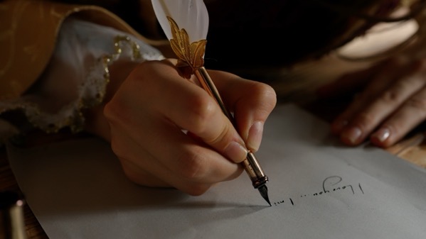 shutterstock_2525907005.jpg Shutterstock 2525907005. A hand writing with a quill an ink.